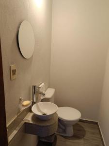 Luque"La serena"的一间带卫生间、水槽和镜子的浴室