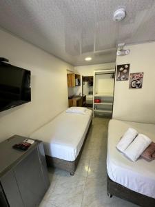 圣安德烈斯Alojamiento turístico Keniant's的酒店客房设有两张床和一台平面电视。