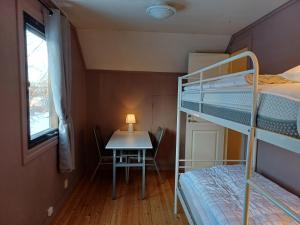 基律纳Kiruna Accommodation Timmermansgatan 23的一间卧室配有一张双层床和一张带台灯的桌子