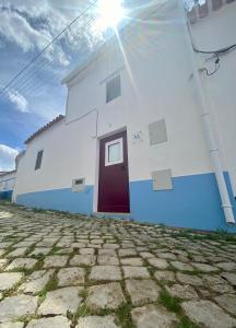 Santa Clara-a-NovaCasa do Serro de Lá的白色和蓝色的建筑,有红色的门