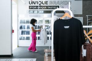 麦德林Indie Universe Creative Hotel的穿着衣服的商店里看到衬衫的女人