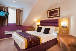 雷迪奇经典英国修道院高尔夫酒店&SPA的酒店客房设有一张大床和一台电视机。