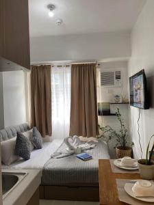 马尼拉Affordable Staycation Studio Rooms Edsa Shaw MRT Greenfield Near Ortigas and Pasig F Residences and Urban deca Shaw的一间小卧室,厨房内配有一张床