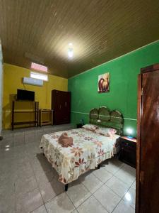 弗洛勒斯Casa Maya Itza的一间卧室设有一张床和绿色的墙壁