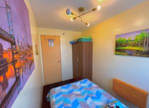 马尼拉Pandora’s Nest的卧室配有一张床,墙上挂有绘画作品