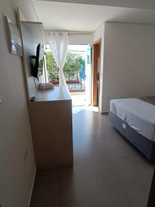 巴拉那州蓬塔尔Residencial Mar Azul-suíte 12的一间卧室配有一张床和一张书桌及电视