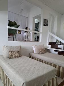 布希奥斯Barracuda Eco Resort Búzios的一间卧室配有两张床和镜子