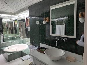布希奥斯Barracuda Eco Resort Búzios的绿色瓷砖浴室设有水槽和镜子