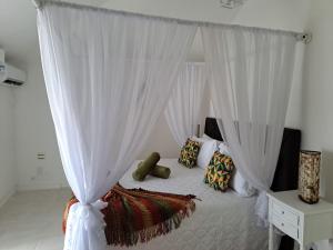 布希奥斯Barracuda Eco Resort Búzios的卧室配有带枕头的天蓬床