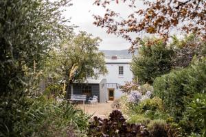 霍巴特Gatekeepers Lodge - A Historic Hobart Experience的花园内带长凳的白色房子