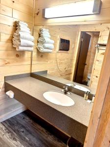 麦基诺城日出海滩汽车旅馆的浴室配有盥洗盆、镜子和毛巾