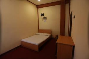 卡图纳耶克Cinnamon Airport Residencies的小房间设有一张床和一张桌子