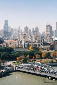 上海上海海鸥丽晶酒店的一座河上的桥梁,以城市为背景