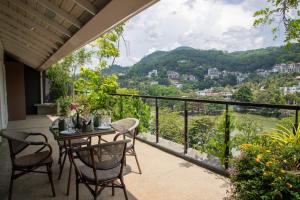 康提Lake Avenue Hotel Kandy的设有一个配有桌椅并享有美景的阳台。