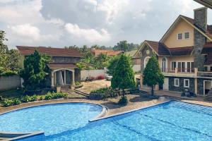 BanjarnegeriUrbanview Hotel Villa Q Gisting的房屋前的大型游泳池