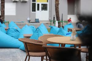 奈扬海滩Panphuree Residence - SHA Extra Plus的一组桌子和椅子,配蓝色枕头