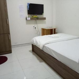 大叻Tường Lan Hotel的一间卧室配有一张床和一台平面电视