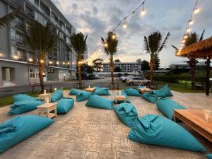 奈扬海滩Panphuree Residence - SHA Extra Plus的一个带蓝色枕头和桌子的庭院和一座建筑