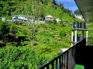 努沃勒埃利耶Summer Glow Guest - Nuwara Eliya的房屋的阳台享有风景。