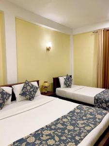努沃勒埃利耶Summer Glow Guest - Nuwara Eliya的酒店客房设有两张床和窗户。
