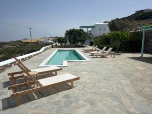 纳乌萨Aegean Queen Villas的一个带躺椅的游泳池和一个游泳池