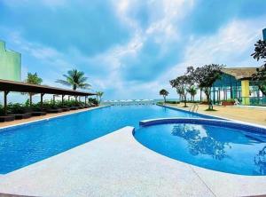 头顿Lfamily Ocean view Apartment 91m2 - ARIA Vung Tau Private Beach Resort, căn hộ Aria Vũng Tàu 91 m2 view biển, bãi biển riêng的大楼前的蓝色海水大型游泳池