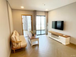 头顿Lfamily Ocean view Apartment 91m2 - ARIA Vung Tau Private Beach Resort, căn hộ Aria Vũng Tàu 91 m2 view biển, bãi biển riêng的一间带电视和沙发的客厅