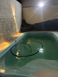 伊塔博拉伊Casa grande com piscina的装满绿水的浴缸,配有水管