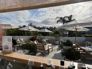 梅林布拉南海汽车旅馆的一个带桌椅和遮阳伞的庭院