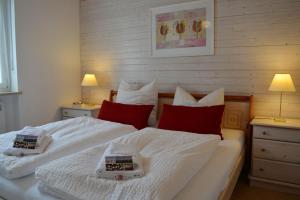 基姆湖畔普林Haus Maja的一间卧室配有两张带白色床单和红色枕头的床。