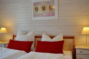 基姆湖畔普林Haus Maja的一间卧室配有两张带红白色枕头的床