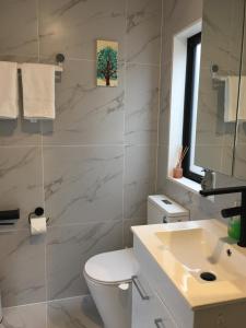 奥克兰West Auckland Delight Stay的浴室配有白色卫生间和盥洗盆。