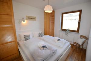 基姆湖畔普林Haus Rehblick的一间卧室配有一张带白色床单的床和一扇窗户。