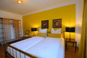 基姆高地区阿绍Zillibilly的卧室设有一张白色大床和黄色的墙壁