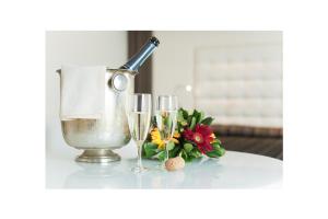 卡塞塔卡塞塔皇家酒店的一张桌子,上面放着两杯香槟酒和一束鲜花