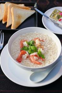 清道奥罗拉墙道度假酒店的盘子里放着一碗带虾和绿的米饭