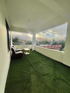 锡卡都Blue Sky Hotel & Restaurant的客厅设有绿色地毯和窗户