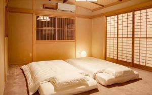 甲州望月庵禅房旅馆的卧室配有两张白色的床。