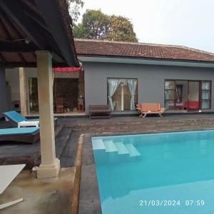罗威那Lovina Villa Cinta的一座带游泳池和房子的别墅
