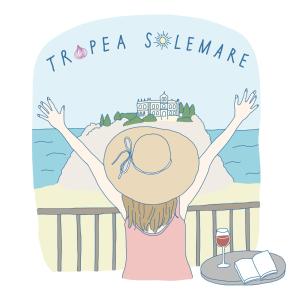 特罗佩阿Tropea Solemare的戴帽子和一杯葡萄酒的女孩,欣赏海景