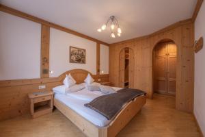 修希伯格霍夫公寓的卧室配有一张床铺,位于带木墙的房间内