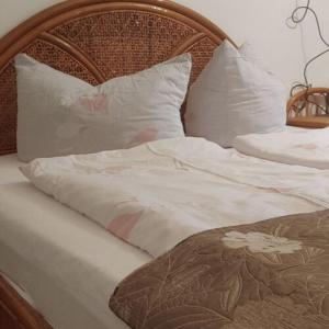 奥巴曹洛克Napsugár Apartman的一张带白色床单和枕头的床