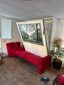 阿姆斯特丹Boat no Breakfast的客厅配有红色沙发和图片