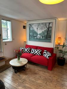 阿姆斯特丹Boat no Breakfast的客厅里一张红色的沙发,配有桌子
