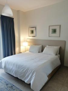 科威特科威特公寓的卧室配有一张带两个枕头的大白色床
