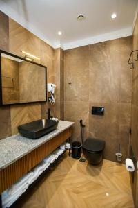 伏罗拉Belvedere Hotel的一间带黑色水槽和卫生间的浴室
