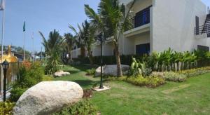 丽贝岛The Green Hotel的棕榈树和房子的建筑的院子