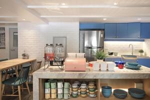 曼谷Simply Sleep Hostel的厨房配有蓝色橱柜和餐具柜