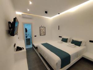 斯科派洛斯Rigas Hotel Skopelos的一间白色卧室,配有床和电视