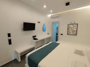 斯科派洛斯Rigas Hotel Skopelos的卧室配有一张床,墙上配有电视。
